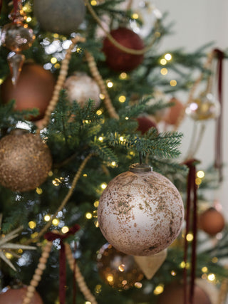 Elegant 5" Mercury Marble Glass Ornament by CG Hunter adorning a beautifully decorated Christmas tree with warm fairy lights.