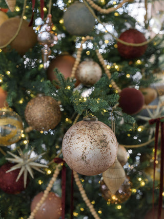Luxurious 3-inch Mercury Marble Glass Ornament by CG Hunter, beautifully displayed among festive decorations on a Christmas tree, highlighting its exquisite craftsmanship.