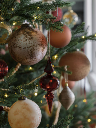 Rich Bordeaux glass finial ornament by CG Hunter, beautifully hanging on a decorated Christmas tree, exuding luxury and charm for festive displays.