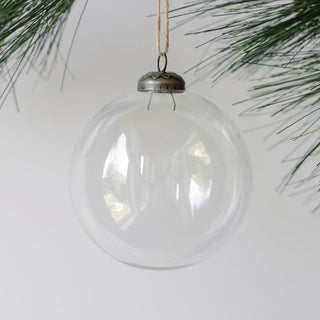 Elegant 4-inch clear glass ornament by CG Hunter, beautifully hanging against a minimalist backdrop, showcasing its timeless design.