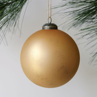 Luxury 4" Matte Antique Gold Glass Ornament by CG Hunter, beautifully suspended from a pine branch, showcasing a rich, matte finish that adds elegance to holiday decor.