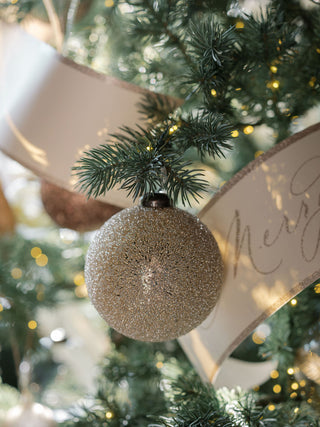 A luxurious 4-inch beaded cream glass ornament hanging on a beautifully decorated holiday tree, showcasing elegance and sparkle, by CG Hunter.