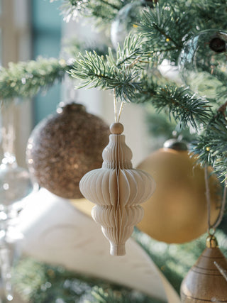 Charming paper ornament by CG Hunter, gracefully displayed on a Christmas tree with golden decorations, exuding holiday elegance and style.