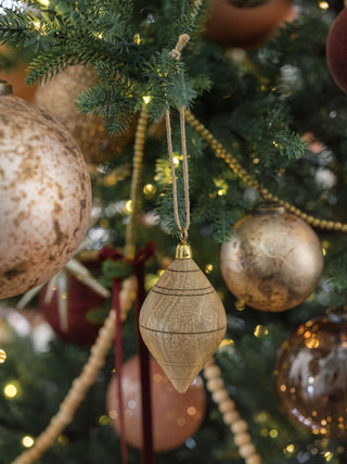 Beautifully crafted Natural Mango Wood Ornament by CG Hunter, elegantly draped among Christmas decorations, highlighting its distinctive design and luxurious appeal.