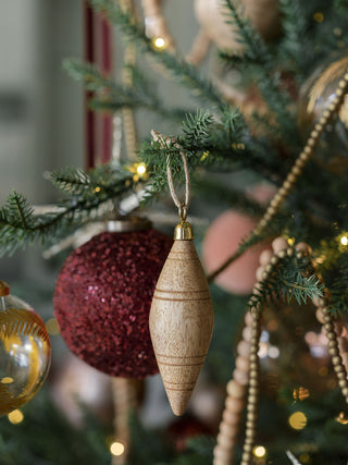 Refined Natural Mango Wood Ornament by CG Hunter, gracefully showcased on a festive Christmas tree with sparkling lights, adding a touch of sophistication to holiday celebrations.