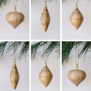 Elegant set of six hand-carved natural mango wood ornaments by CG Hunter, featuring assorted shapes and a brass topper, perfect for adding a luxurious touch to your Christmas tree.