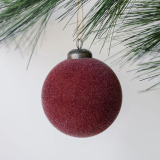 Elegant 3" Flocked Bordeaux Glass Ornament by CG Hunter, featuring a soft, velvety texture, beautifully suspended from a branch, perfect for adding a luxurious touch to your holiday decor.
