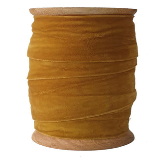 A spool of CG Hunter's luxurious hand dyed velvet ribbon in rich golden hue, ideal for elegant crafting, gift wrapping, and holiday decor projects.