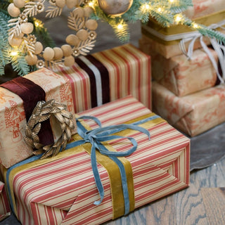 Charming collection of holiday gifts meticulously wrapped in festive paper, adorned with CG Hunter's hand dyed velvet ribbons, creating a luxurious holiday display.