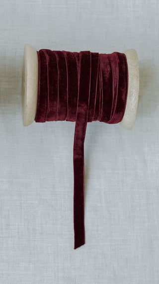 Elegant hand-dyed velvet ribbon from CG Hunter, 10 yards per spool, in deep burgundy color, perfect for sophisticated floral arrangements and seasonal styling.