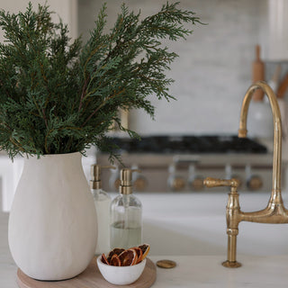 A beautifully styled kitchen scene featuring a 36" Cedar Tree by CG Hunter in a chic ceramic vase, adorned with organic touches for a modern aesthetic.