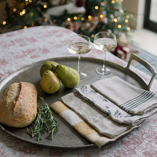 Elegant dining setting featuring CG Hunter Striped Napkins in black and ivory, alongside a loaf of bread and fresh pears on a decorative tray, perfect for sophisticated gatherings.