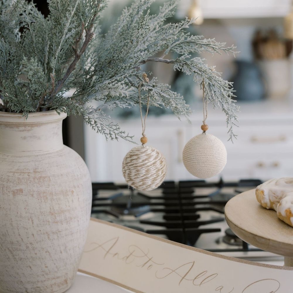 Close-up of the 27" Flocked Cedar Stem by CG Hunter, adorned with handcrafted ornaments, enhancing a stylish and festive kitchen decor.