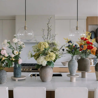 Decorative vases with flowers on a kitchen counter