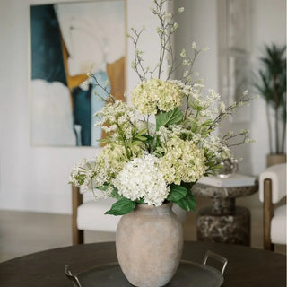 Floral arrangement in a vase on a table with a blurred indoor setting