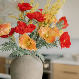 Vase with red and orange flowers in a kitchen setting
