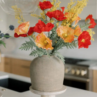 Vase with red and yellow flowers on a kitchen counter