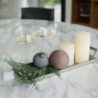Elegant serving tray with handles by CG Hunter, featuring a pewter finish, beautifully arranged with wine glasses, candles, and decorative ornaments on a marble table.