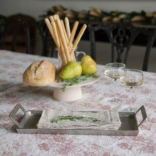 Sophisticated serving tray with handles by CG Hunter, showcasing a rustic setting with bread, pears, and elegant wine glasses, set on a floral tablecloth.