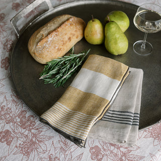 Charming display of CG Hunter Striped Napkins in black and ivory, styled with fresh pears and a rustic loaf of bread on a metal serving tray, ideal for upscale dining experiences.