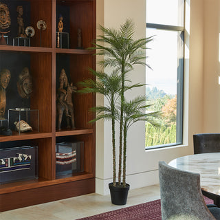 Chic dining area featuring the 7' Artificial Palm Tree by CG Hunter, adding a touch of greenery next to elegant decor and natural light.