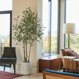 Luxurious interior featuring the 7' Artificial Willow Eucalyptus Tree with Artisan Planter by CG Hunter, adding elegance to a modern living space.