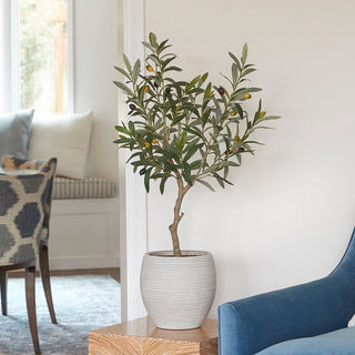 Elegant artificial Olive Topiary Tree by CG Hunter, showcasing its realistic design in a stylish interior setting, enhancing the ambiance of modern decor.