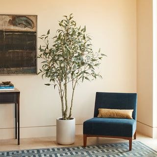 Chic corner display of the 7' Artificial Willow Eucalyptus Tree with Artisan Planter by CG Hunter, enhancing a stylish room atmosphere.