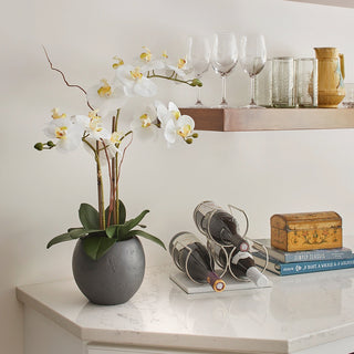 Stylish artificial White Double Stem Orchid by CG Hunter nestled in a contemporary grey pot, enhancing the beauty of a sophisticated tabletop with wine accessories.