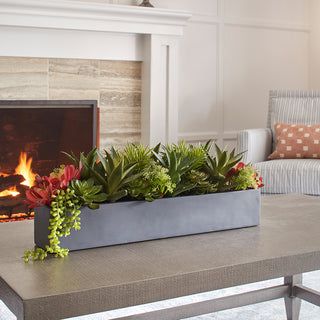 Chic living room setting featuring the CG Hunter rectangular artificial succulent arrangement, beautifully styled on a coffee table near a cozy fireplace.