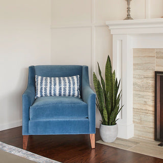 Elegant living space featuring Commercial Artificial Snake Plant in Artisan Planter by CG Hunter, placed beside a stylish blue armchair, enhancing the room's decor with greenery.