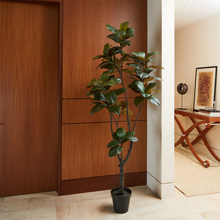 Chic interior displaying a 7' Artificial Magnolia Tree by CG Hunter against a warm wood backdrop, adding a touch of elegance to home decor.