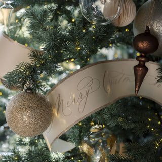 Close-up of a stunning 4-inch beaded cream glass ornament featured among other exquisite decorations on a festive tree, designed by CG Hunter.