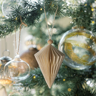 A beautifully crafted paper ornament and the 3" Artisan Glass Gold Etched Leaf Ornament by CG Hunter, displayed on a lush Christmas tree, perfect for a lavish holiday decoration theme.