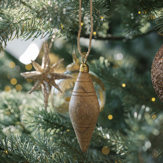 Close-up of a beautifully crafted wooden ornament hanging from a Christmas tree, surrounded by twinkling lights and elegant decorations. Featuring CG Hunter's 2.75" Gold Glitter Starburst Ornament, this image exudes holiday charm.