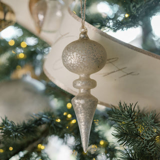 Charming glass finial ornament in a frosted finish hanging on a Christmas tree, part of the luxurious assortment by CG Hunter.