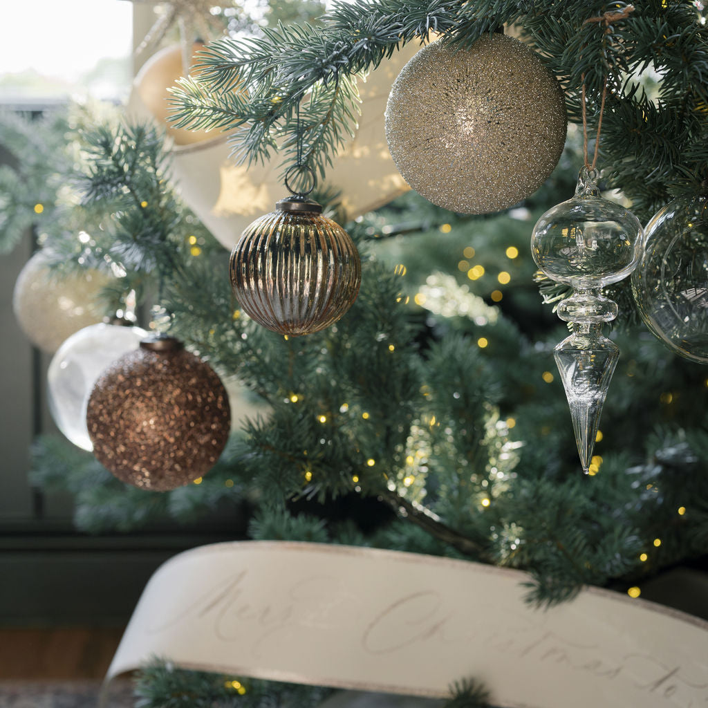 4" Beaded Cream Glass Ornament - Set of 4 closeup with a selection of Mindight Star ornaments and paper banner garland