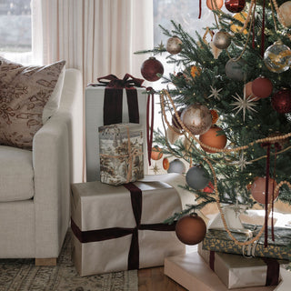 Chic display of gifts beneath a decorated tree featuring elegant 3" Flocked Bordeaux Glass Ornaments by CG Hunter, showcasing a luxurious and inviting holiday setting.