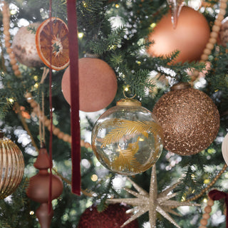 Chic arrangement of festive decorations, featuring the 4" Beaded Antique Bronze Glass Ornament by CG Hunter, surrounded by a variety of holiday ornaments, conveying a luxurious Christmas ambiance.