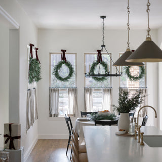 Elegant kitchen featuring multiple 30" Faux Evergreen Cedar Wreaths by CG Hunter, adorning windows with luxurious greenery and festive decor.
