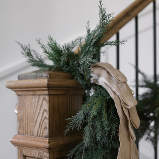 Artful display of hand-dyed velvet ribbon intertwined with fresh greenery on a staircase, showcasing CG Hunter’s Hand Dyed Velvet Ribbon 10 Yards Per Spool.
