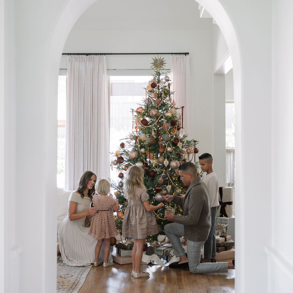 Family in front of Timeless Collection tree in awe of the beauty