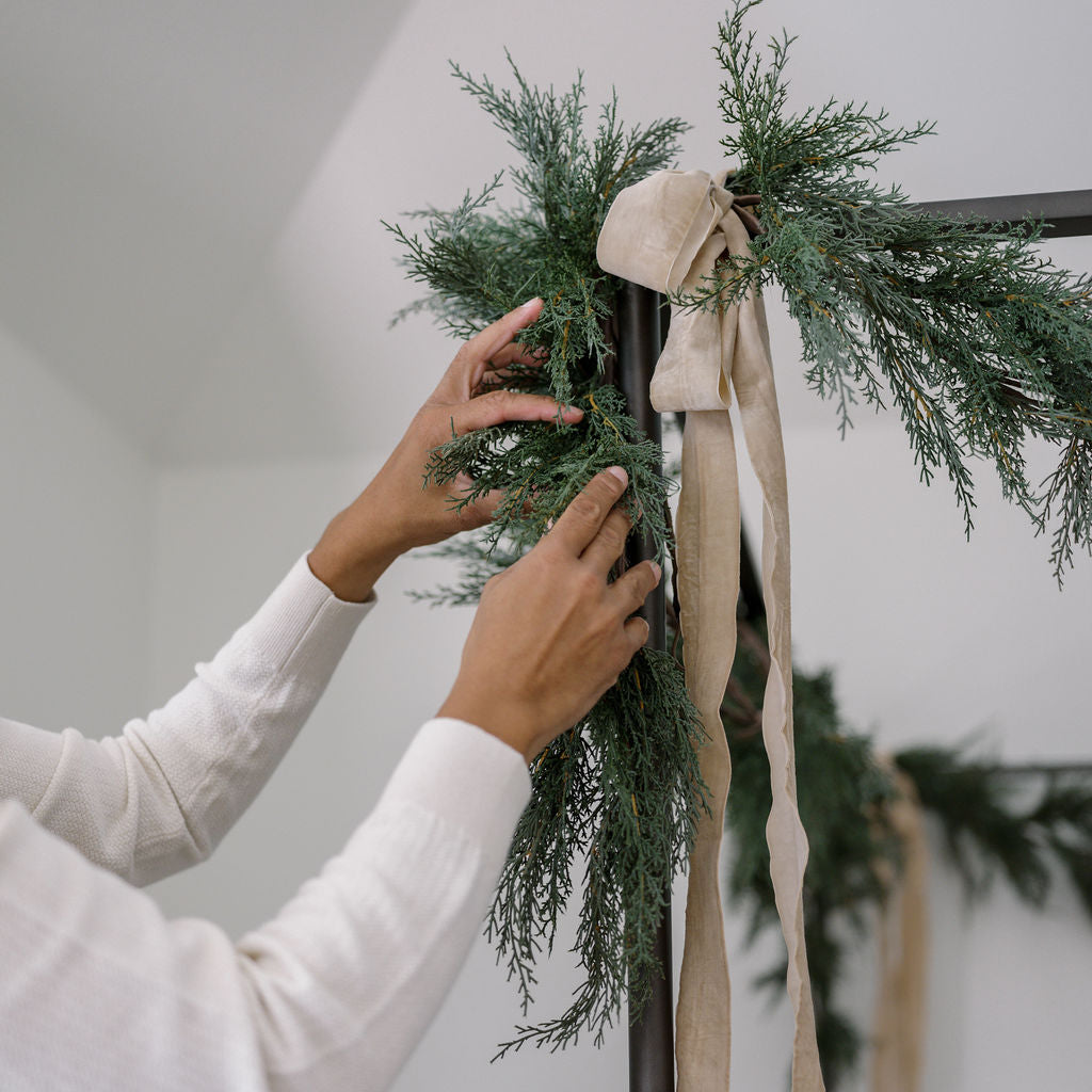 Wide velvet ribbon with garland on bed frame