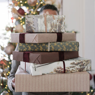Close-up of wrapped gifts showcasing rich textures of paper and hand dyed velvet ribbons, reflecting luxury gift wrapping ideas with CG Hunter's Hand Dyed Velvet Ribbon 10 Yards Per Spool – Set of 2.