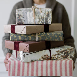 A stack of beautifully wrapped gifts featuring hand-dyed velvet ribbon, embodying elegance and charm with CG Hunter’s Hand Dyed Velvet Ribbon 10 Yards Per Spool.