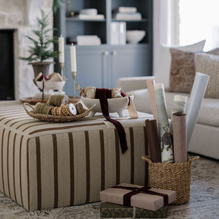 Luxury home decor scene featuring CG Hunter’s Hand Dyed Velvet Ribbon 10 Yards Per Spool – Set of 2, displayed with a variety of gift-wrapping supplies on a stylish ottoman.
