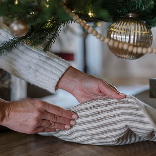 Chic Ticking Stripe Reversible Tree Skirt by CG Hunter, elegantly draped under a decorated Christmas tree, highlighting its sophisticated design.