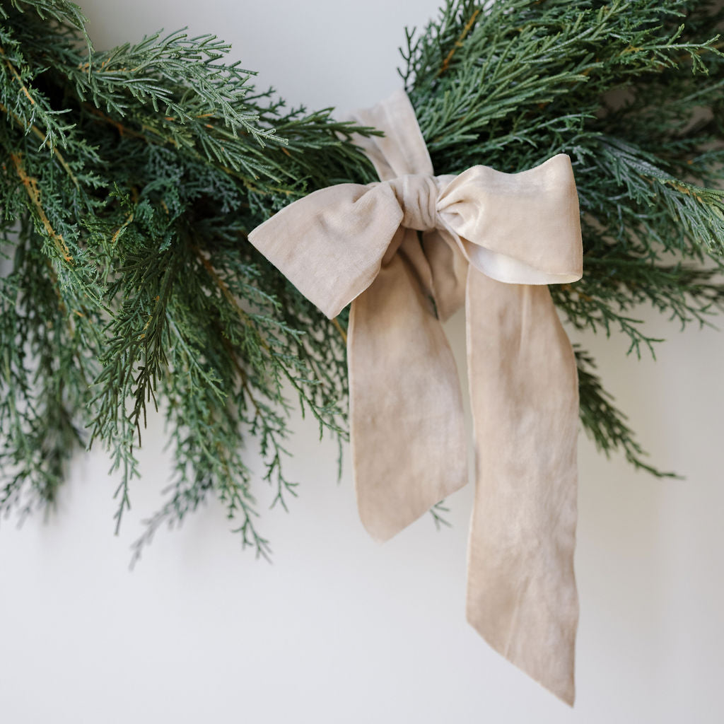 Close up of 30" Lifelike Cedar Wreath with wide velvet ribbon