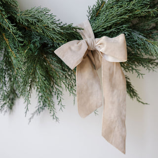 Chic close-up of a bow accent on the 30" Faux Evergreen Cedar Wreath by CG Hunter, emphasizing luxury decor.