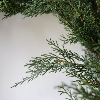 Detailed shot of faux cedar foliage showcasing realistic texture and color, from the 30" Faux Evergreen Cedar Wreath by CG Hunter.
